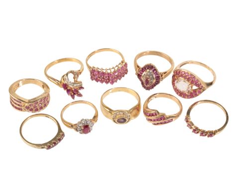 A RUBY CLUSTER RING, the wide shaped band pave set to one side with round-cut ruby accents, channel set to the other with thr