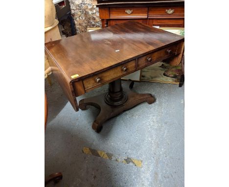 A 19th century mahogany sofa table with twin fall flaps and a pair of drawers, over a turned column, on a quadruped base 72cm