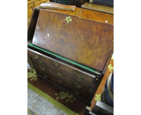An early 18th Century walnut veneered bureau with feathered edge banding, fall flap with brass escutcheons and key revealing 