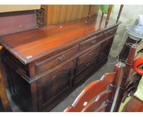 A reproduction sideboard with three short drawers over three central drawers flanked by cupboard doors on bracket feet 87cm x
