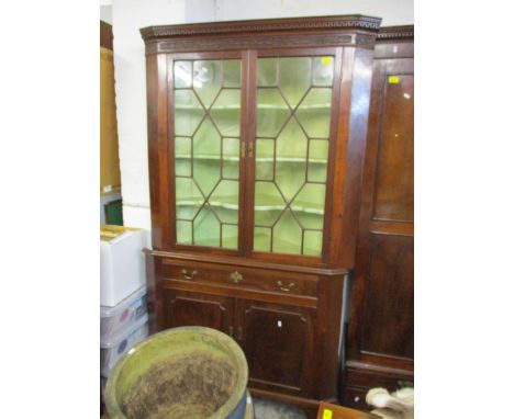 A George III mahogany corner cabinet, stepped corner with carved decoration above a band of blind fretwork, twin astragal gla