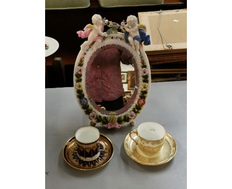 A Wedgwood china cup and saucer, a 19th century cup and saucer and a late 19th century German porcelain easel mirror decorate