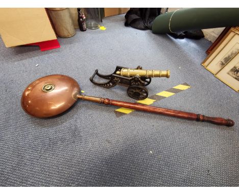 An early 20th century cast iron and brass model cannon and a copper warming pan 