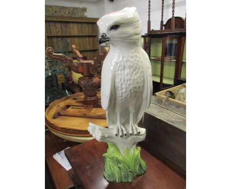 A large Italian ceramic model eagle perched on a branch and naturalistic base, 84cm high 