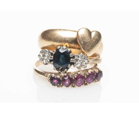 GOLD RINGS comprising 9ct gold sapphire and diamond illusion ring, 9ct gold five stone ruby ring, yellow metal heart ring, 10