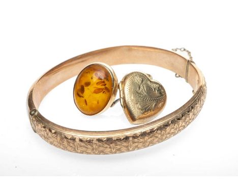 GOLD JEWELLERY comprising 9ct gold engraved hinged bangle, 9ct gold heart locket, 9ct gold amber ring19.8gms gross (3)Provena