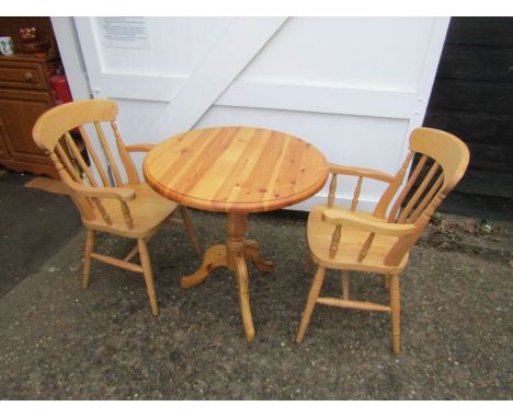 Round pedestal Pine table with 2 carver chairs. Table diameter 77cm approx 