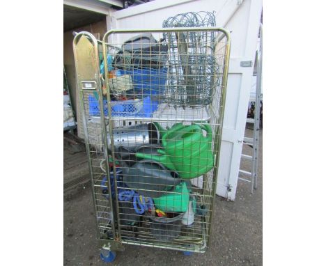 Stillage containing garden items and tools including watering cans, workbench, hosepipe and fencing etc