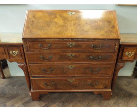 A Georgian walnut bureau with fitted interior and four long drawers under with brass four handles standing on bracket feet 3'