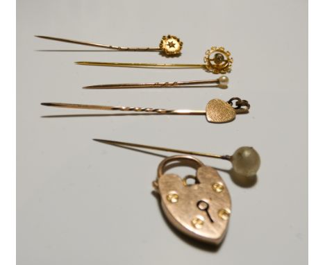 Five stick pins to include a Victorian diamond set example and a 9ct gold padlock fastening 