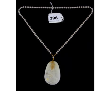 A Chinese carved white jade amulet of the Guanyin on a white jade bead necklace.