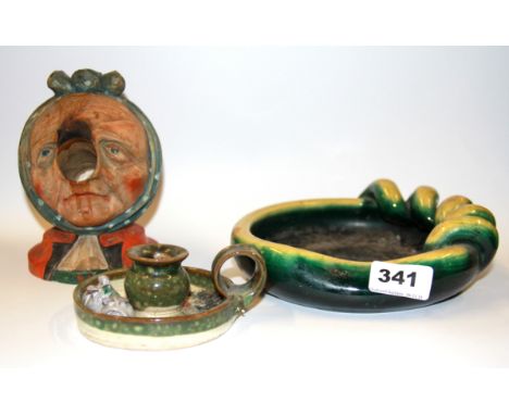 A 1947 carved wooden Black Forest amusing head of an old lady with a ceramic chamber stick and ceramic bowl, lady H. 15cm.