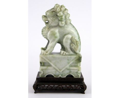 A fine Chinese carved jade lion dog figure on a carved wooden base, overall H. 18cm.