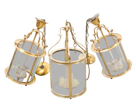 A PAIR OF BRASS THREE-LIGHT HALL LANTERNS 20th century, of circular section, with glazed panelling, each 48cm high x 25cm acr