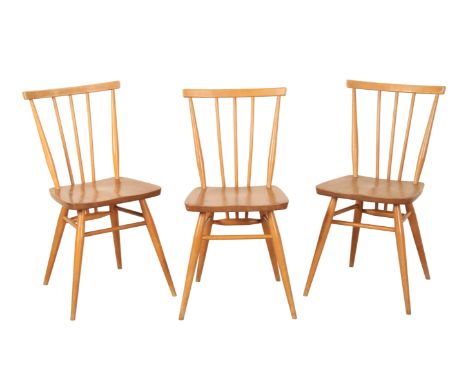 A SET OF THREE ERCOL BLOND ELM 'ALL PURPOSE WINDSOR' CHAIRS with curved crest rails and spindle backs, each 78cm high x 40cm 