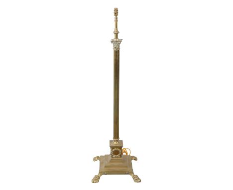 A BRASS COLUMNAR STANDARD LAMP 19th century, with a Corinthian capital on a reeded stem, to a pedestal base on lions paw feet