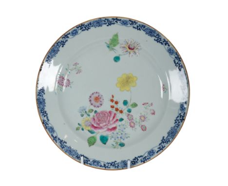 A CHINESE FAMILLE ROSE EXPORT PLATE Qianlong, decorated with floral sprays in bring enamels and a blue floral scroll border, 