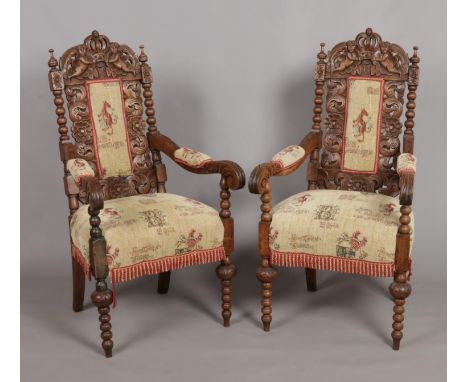 A pair of carved oak throne chairs. Having cherub and crown detailing to the back rests and bobbin turned supports.