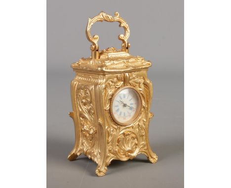 A miniature French gilt carriage clock in the Art Nouveau style. Height with handle 10cm.