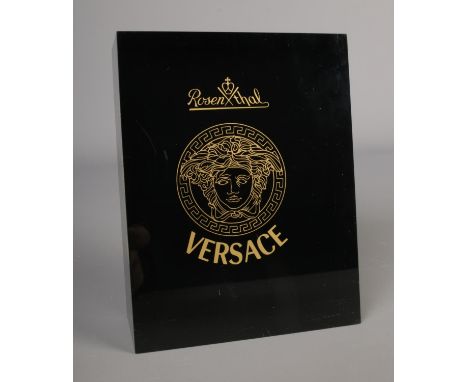 A Versace resin shop display plaque.