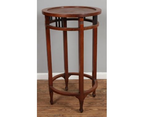 A Indonesian style tall round table with pierced apron and stretchers resting on arrow feet.Hx105cmDx60cm