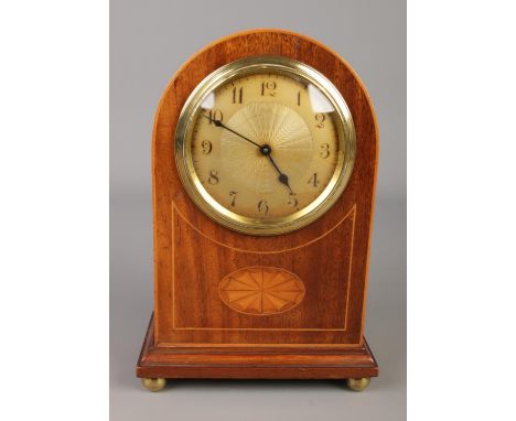 A small French mahogany inlaid mantle clock with Arabic numeral dial and raised on brass ball feet. Approx. height 22cm.