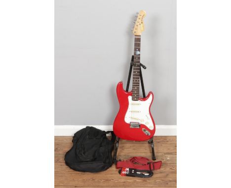 A red "Sunn Mustang" Electric Guitar by FMIC (Fender Musical Instruments Corporation), Made in Canada, accompanied by a pick,