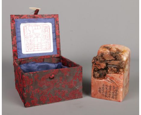 A Qing dynasty Chinese "Shoushan" stone seal, crafted from reddish-hued natural stone, intricately hand-carved with a traditi