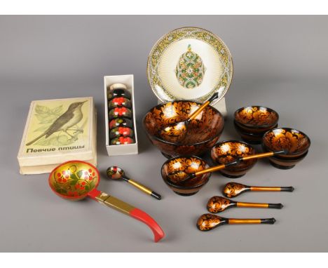 A collection of vintage items from Eastern Europe, featuring a set of USSR Khokhloma painted bowls, spoons, and napkin rings,