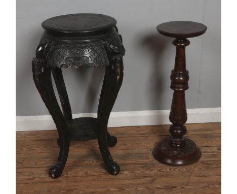 A Chinese two tier hardwood plant stand featuring heavily carved supports along with a smaller turned example. Approx. height