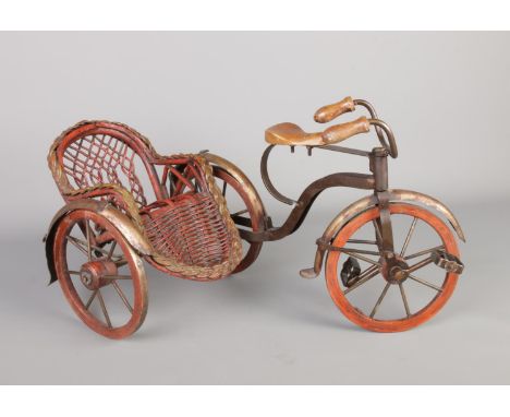 A vintage richshaw pedicab, made with a combination of wicker and metal, wheels and pedals can move.  Length 49cm, height 26c