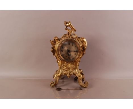 A late 19th century rococo themed brass mantle clock, 39cm, with 30 hour drum movement, pendulum and key