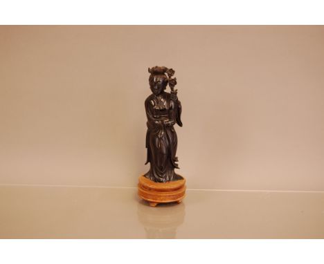 A vintage Chinese carved figure, 17cm high, on wooden base, damaged, possibly cherry amber