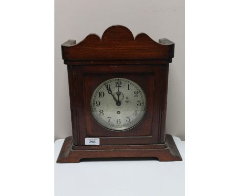 A brass ship's clock contained within a mahogany mantle type case.