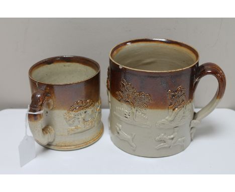 Two antique stoneware mugs depicting hunting and farming scenes. (2)