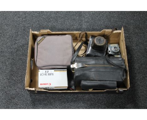 A box containing five cameras to include a Praktica leather cased camera in bag with ;lenses, a Zenit 3M camera, Olympus OM10