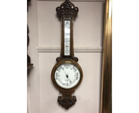 A carved oak aneroid barometer 