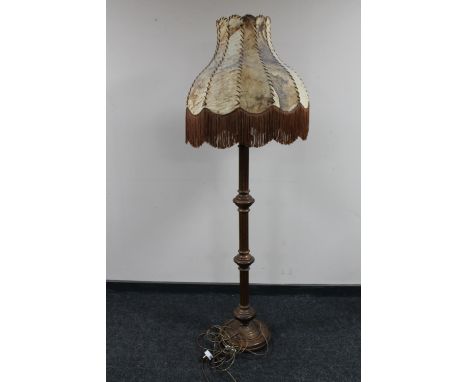 An antique oak standard lamp with an animal hide shade 