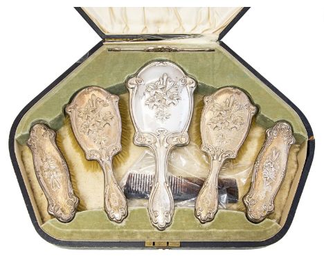 An Arts and Crafts silver six piece brush and mirror set, embossed in the Art Nouveau style with lily motif within  sinuous t