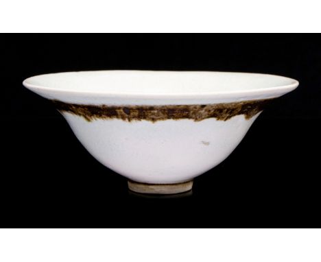 Dame Lucie Rie, a studio porcelain bowl, footed, flared form with everted rim, pale blue orange peel glaze with brown band to