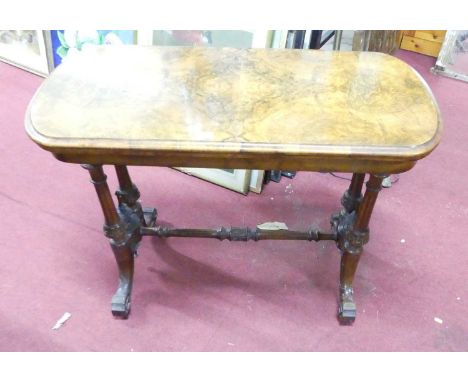 A mid-Victorian figured walnut fold-over baize lined card table, having a swivel top with thumb moulded edge, raised on twin 