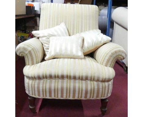 A late Victorian walnut framed and silk striped upholstered easy chair, having rolled arms and raised on ring turned forelegs