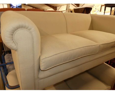 A pair of contemporary plain cloth fabric upholstered three-seater sofas, each raised on squat bun supports with twin squab s