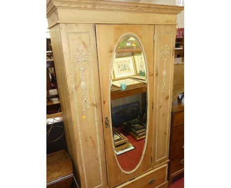 An Edwardian pine single mirror door wardrobe, having single long lower drawer with raised floral detail, width 113cmSome lig