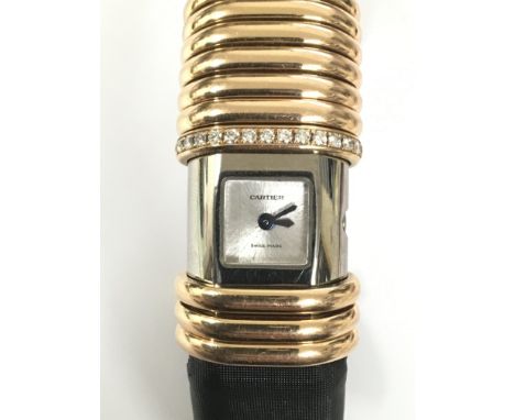 A ladies petite Cartier 15mm titanium and 18K rose gold declaration watch. The small square dial is of brushed metal design w