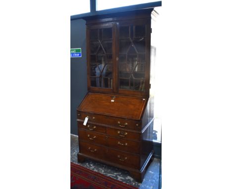 An 18th century oak bureau bookcase, with astragal glazed doors enclosing adjustable shelves over a slope fall enclosing a fi