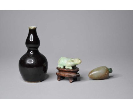 A Chinese jade snuff bottle in the form of a peach, 18th/19th century, the pale green stone with light ochre inclusions, 5.5c