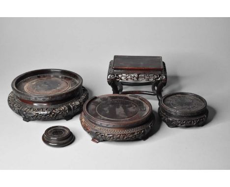 A collection of Chinese hardwood vase stands, Qing DynastyThree of circular form with carved openwork bases, 12-19cm, a small