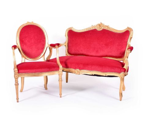 A pair of 19th century, Louis XVI style, gilded armchairs, with tapering cylindrical legs and covered in a wine red fabric; w