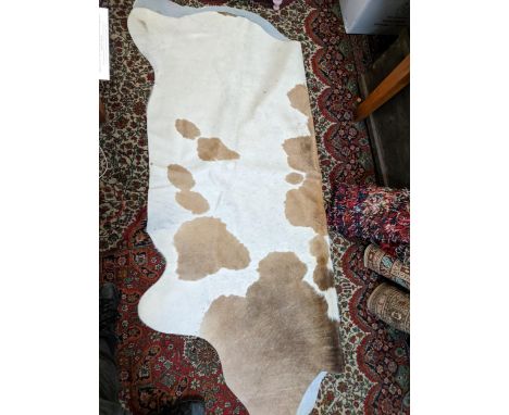 A cow hide rug and a Lloyd Loom pink painted ottomanLocation: GMIf there is no condition report shown, please request